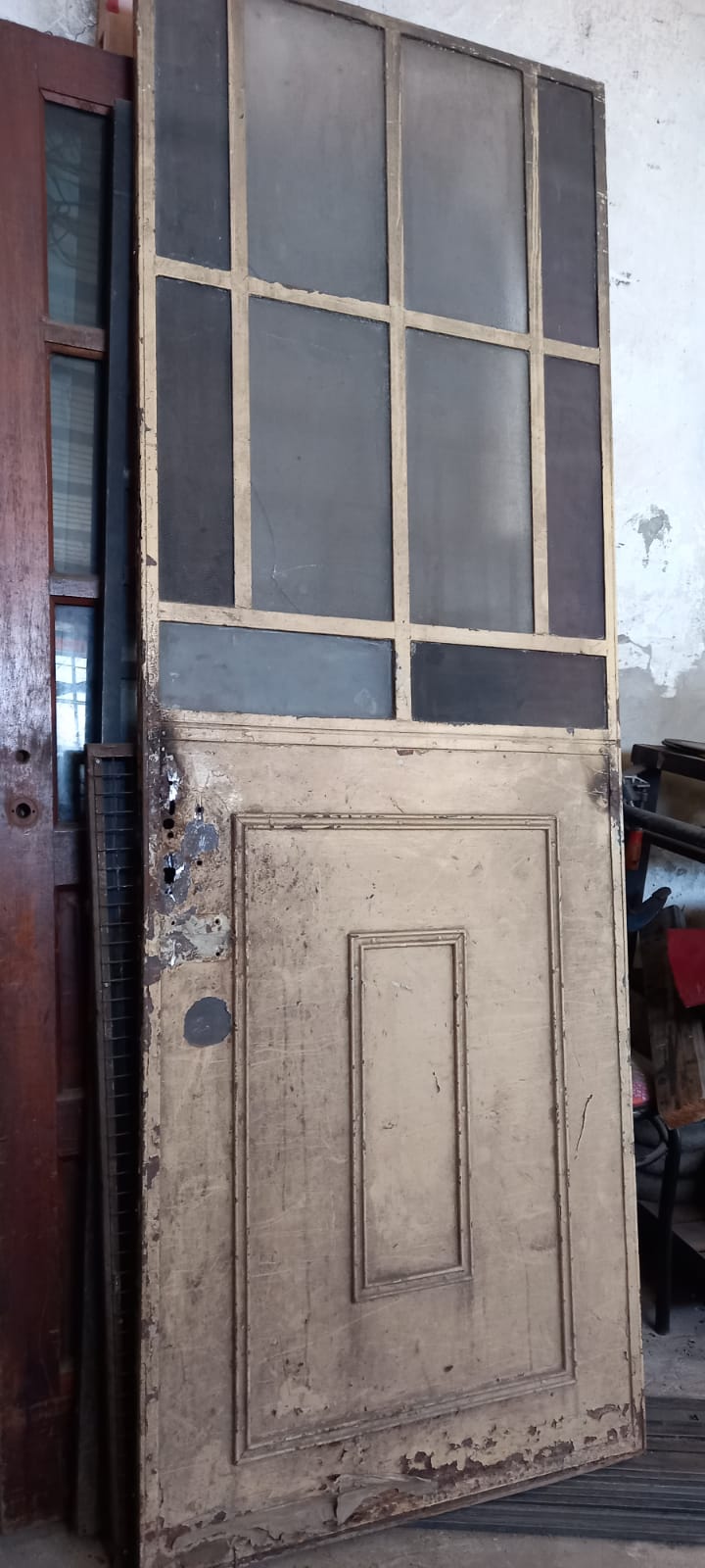 Puerta antigua antes de la restauración, con pintura gastada y sectores deteriorados