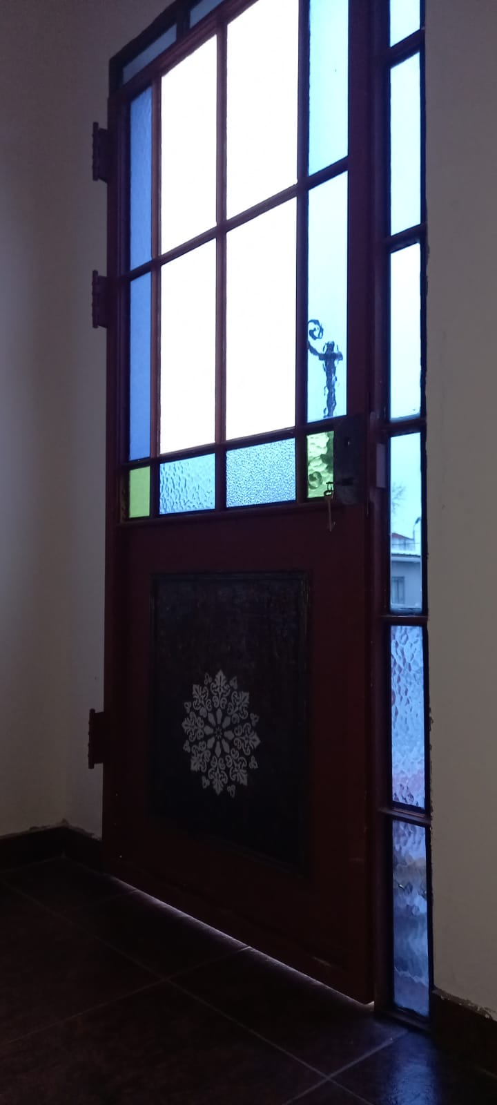Puerta recuperada e instalada, con la luz atravesando sus vidrios