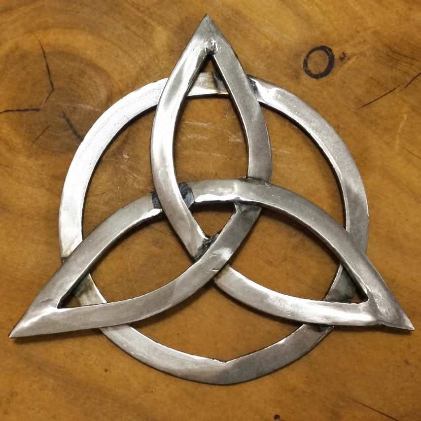La triqueta terminada: tres formas entrelazadas, un aro y la textura del metal.