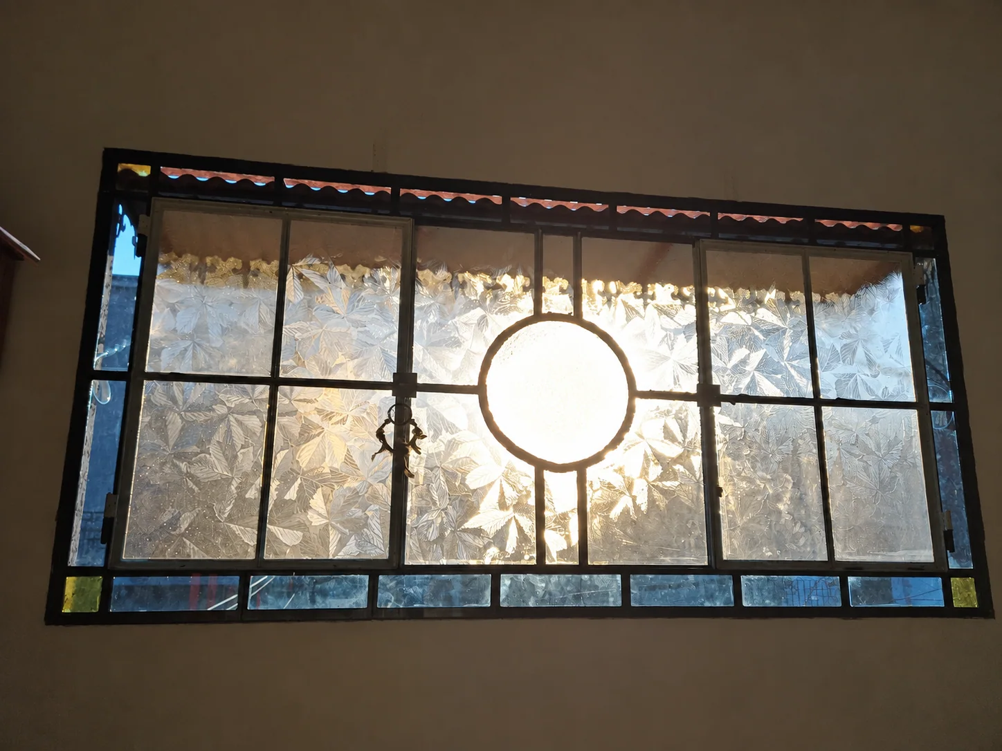 La luz entra por el ventanal de hierro y vidrio del taller.