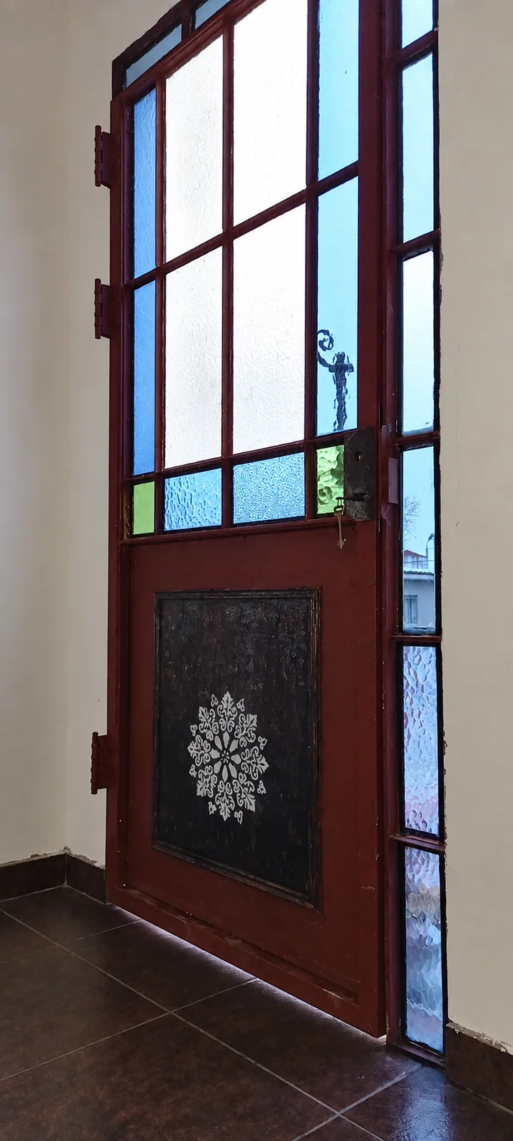 La puerta restaurada e instalada, con la luz atravesando el vidrio.